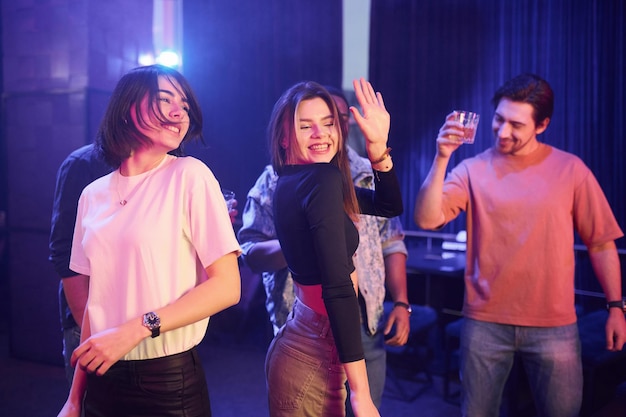 Danser ensemble Groupe d'amis s'amusant dans la boîte de nuit