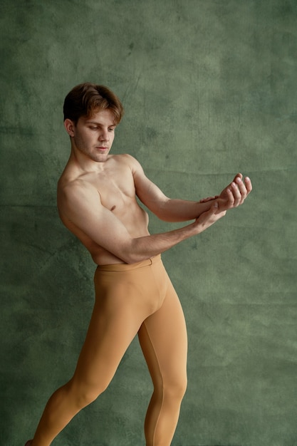 Danseur de ballet masculin, formation en cours de danse, mur de grunge. Interprète au corps musclé, élégance des mouvements
