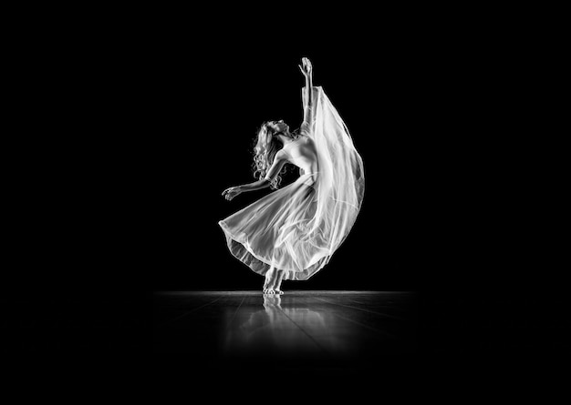 Un danseur blanc danse sur un fond noir avec un fond noir.