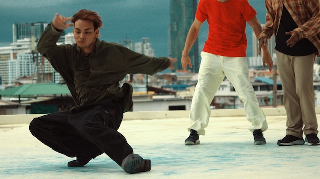 Photo danseur de break asiatique en train de danser avec ses amis sur le toit.