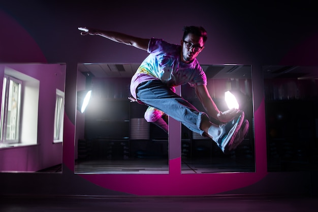 Danseur de break professionnel en mouvement, pratiquant la danse hip-hop moderne en néon rose