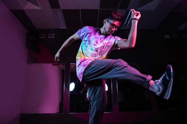 Danseur de break professionnel en mouvement, pratiquant la danse hip-hop moderne en néon rose