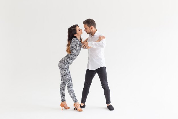 Danseurs habiles se produisant sur fond blanc avec espace de copie. Couple sensuel exécutant une danse contemporaine artistique et émotionnelle