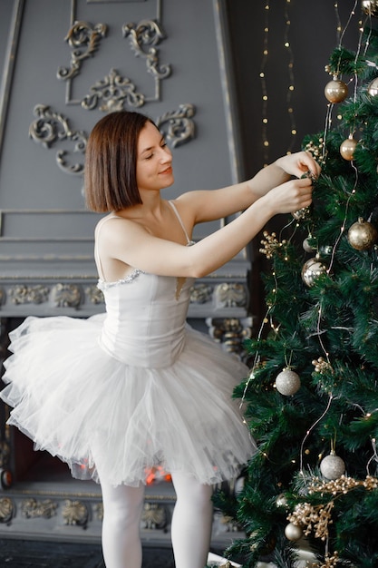 Danseuse de ballet féminine en tutu blanc décorant le sapin de Noël
