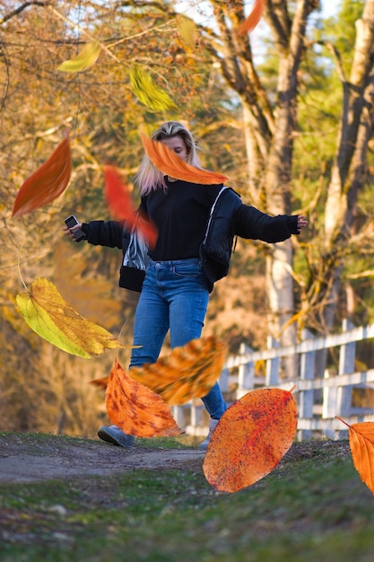 Danseuse blonde dans un parc d'automne coloré