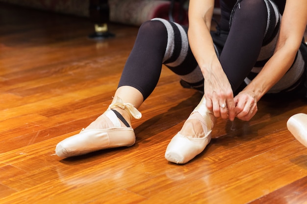 Danseuse classique ajustant ses chaussures