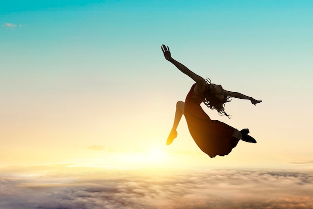 Danseuse contre le coucher du soleil et les nuages. Technique mixte