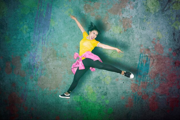 Photo une danseuse sautant haut dans le studio.