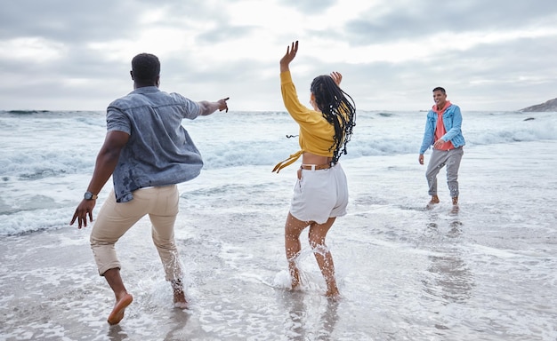 Dansez sur l'eau ou des amis fous sur une plage pour vous détendre pendant les vacances, en vous liant dans la nature à Bali Des hommes excités drôles et des groupes de femmes heureuses dansant en mer aiment voyager en mer