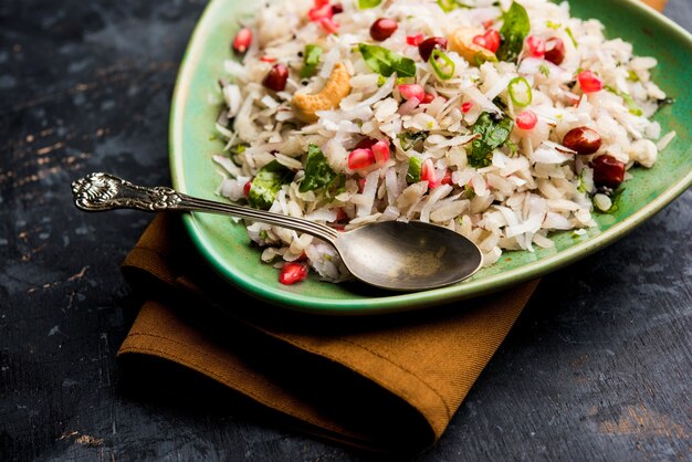 Photo le dapde pohe est un petit-déjeuner typique du maharashtrian, composé d'une fine variété de poha et de noix de coco fraîche avec du piment, des cacahuètes et des noix. servi dans un bol ou une assiette. mise au point sélective