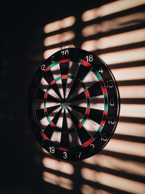 Dartboard sur le mur avec l'ombre à la maison