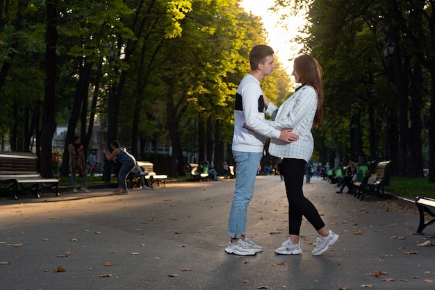 Date dans le parc. Guy et fille câlin dans le parc au coucher du soleil