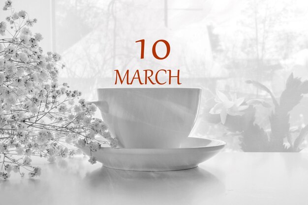 Date du calendrier sur fond clair avec paire de thé blanc en porcelaine et gypsophile blanche 10 mars