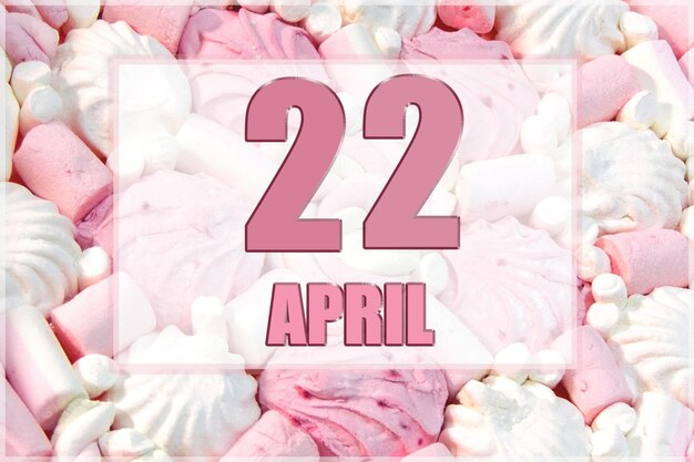 Date du calendrier sur fond de guimauves blanches et roses Le 22 avril est le vingt-deuxième jour du mois