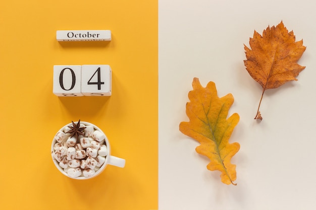 Date du calendrier, tasse de cacao aux guimauves et feuille d'automne jaune