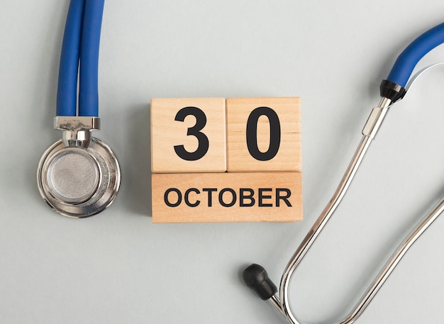 Date médicale d'octobre sur le calendrier en bois avec stéthoscope recadré