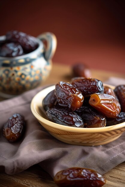 dates brunes savoureuses à l'intérieur de la plaque sur le bureau en bois focalisation sélective