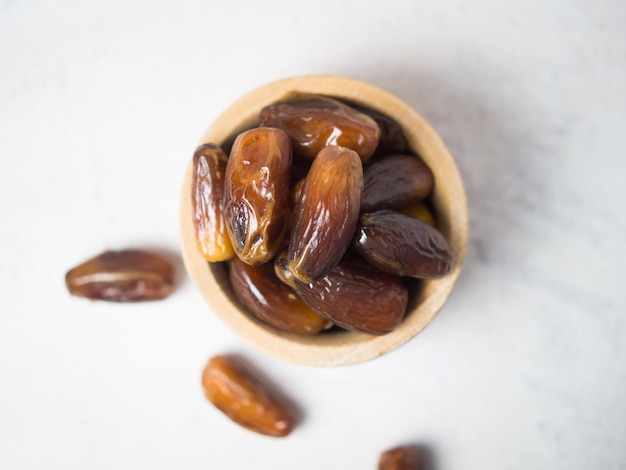 Dates dans un bol en bois sur un espace de copie de table en béton gris