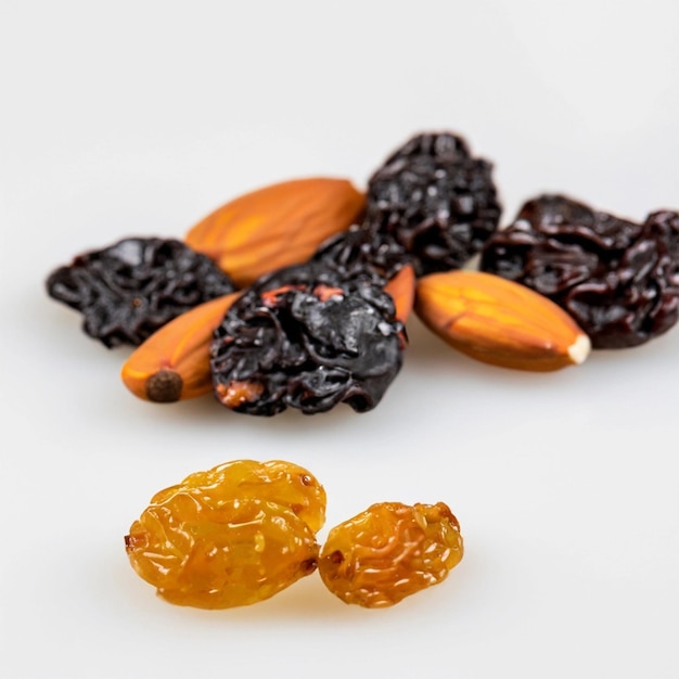 Les dattes d'abricots secs et les raisins secs multicolores se trouvent sur un fond blanc