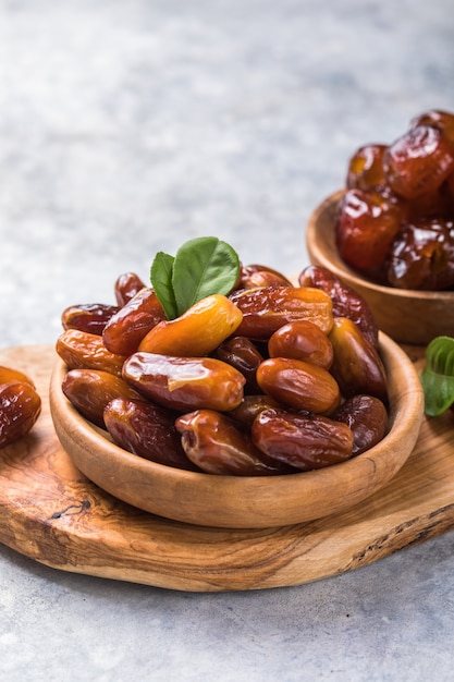 Photo dattes ou fruits de palmier dattes dans un bol en bois est une collation saine.