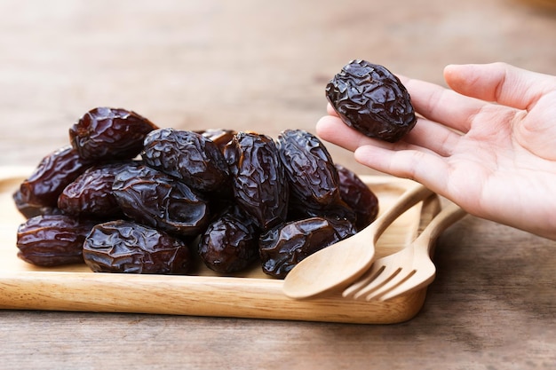 Photo les dattes séchées medjool tenues dans les mains d'une femme sont un fruit riche en nutriments