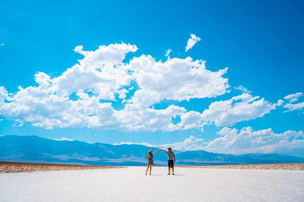 Death Valley, Californie, États-Unis. Un couple de touristes se cogner la main sur le sel blanc du bassin de Badwater