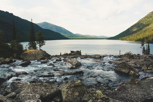 Débit de la rivière avec d'énormes pierres. La rivière se jette dans le lac Multinskoe. Bruit entre les deux lacs. Altaï Russie