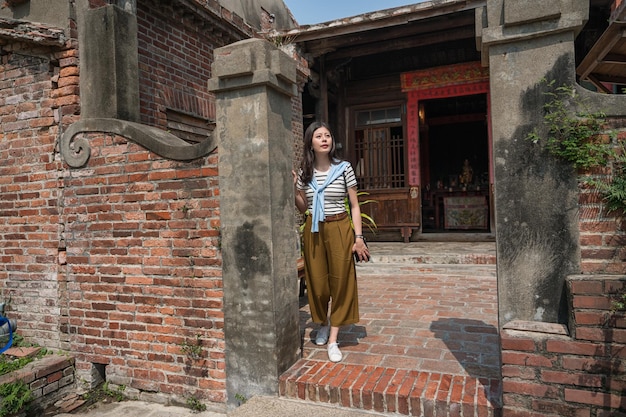 debout dans l'ancienne maison traditionnelle. femme asiatique visitant l'une des plus anciennes maisons.