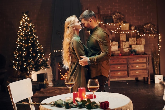 Debout et dansant Un jeune couple charmant a un dîner romantique à l'intérieur ensemble