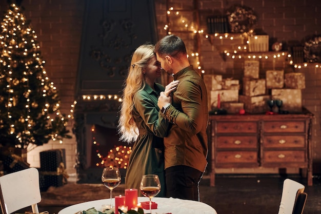 Debout et dansant Un jeune couple charmant a un dîner romantique à l'intérieur ensemble