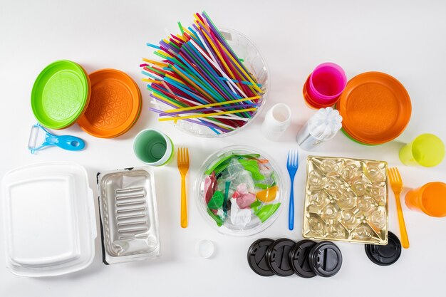 Debout ensemble. Des trucs toxiques colorés en plastique nocif debout sur une surface blanche comme exemples de notre consommation chaotique