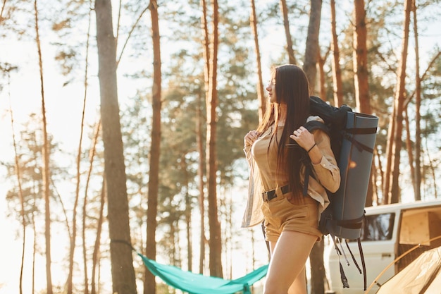 Debout près de la tente Une femme voyage seule dans la forêt pendant la journée en été