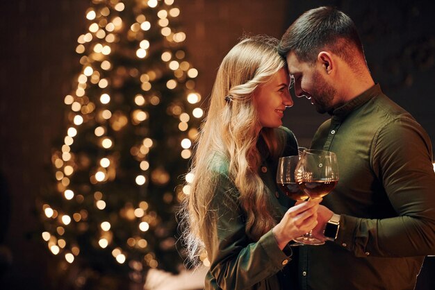 Debout et s'embrassant Un jeune couple adorable dîne ensemble à l'intérieur