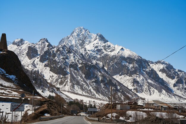 Début du printemps. Le village est dans les montagnes. Bonnets de neige au sommet des montagnes. Petit village au pied.