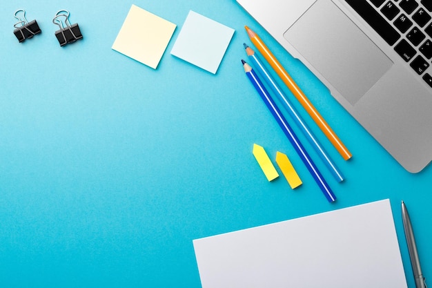 Début de matinée bureau de travail avec ordinateur portable crayon Feuille de papier bloc-notes stylo bleu texture table Business concept background