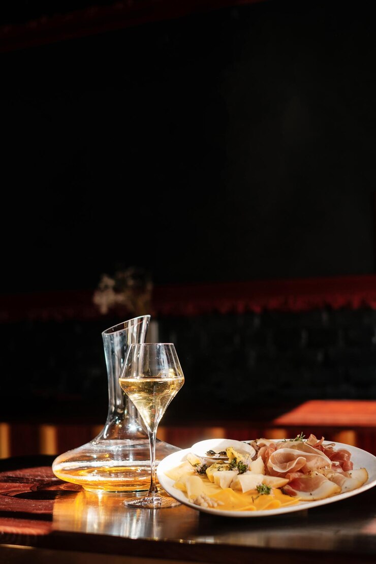 Décanteur et un verre de fromage à vin avec de la confiture de fruits et de noix