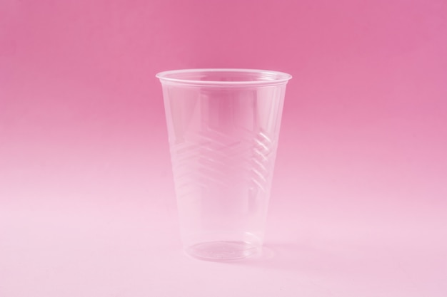 Déchets de verre en plastique jetable sur rose.