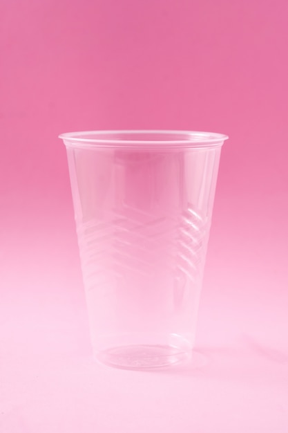 Déchets de verre en plastique jetable sur rose.