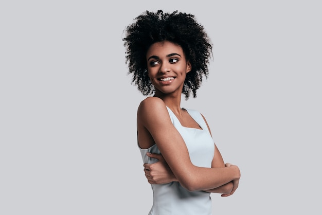 Décontracté et beau. Jeune belle femme africaine en tenue décontractée en gardant les bras croisés