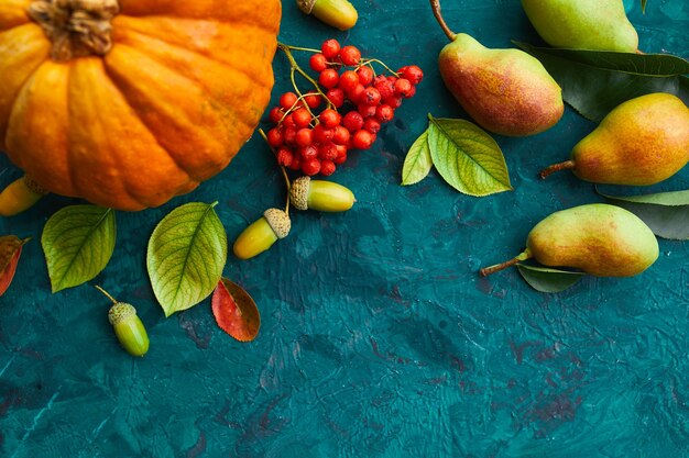 Décor d'automne festif avec citrouilles, poires, feuilles, glands et baies