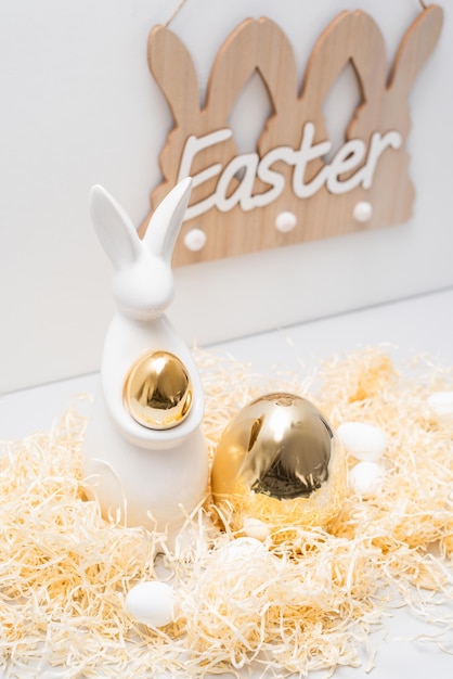 Le décor du lapin d'ester doré est un concept de vacances de chaume et d'œufs.