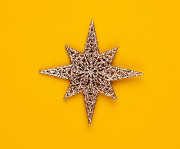 Décor d'étoile de Noël sur fond de couleur jaune.