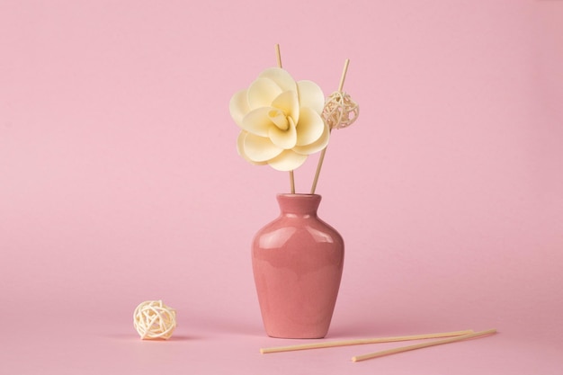 Décor de fleurs et bâtons d'encens sur fond rose