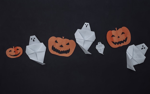 Photo décor d'halloween découpé en papier fait main sur fond noir. citrouille d'halloween et fantômes