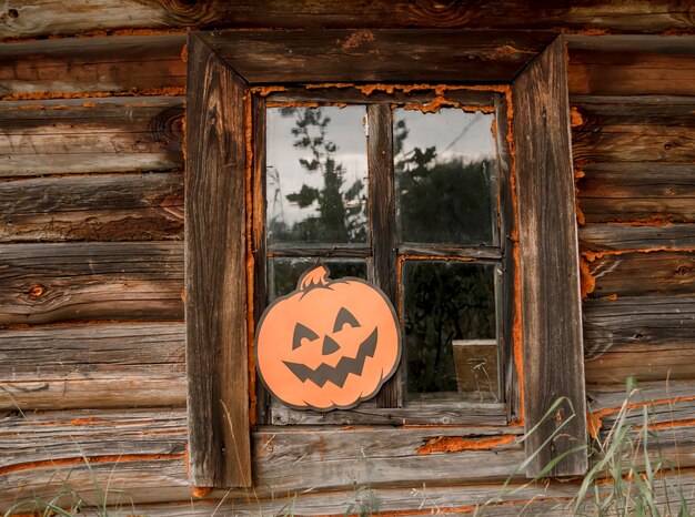 Décor d'Halloween à l'extérieur. Citrouille en papier citrouille sur la fenêtre en bois de l'ancien bain public.