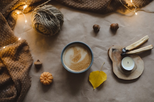 Décor à la maison confortable de hygge de temps d'automne avec un plaid de bougies de tasse