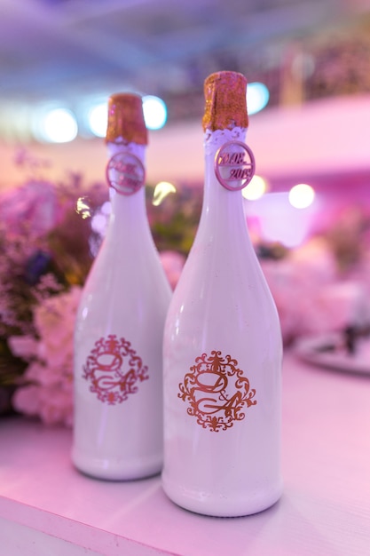 Décor de mariage de bouteilles de champagne sur le fond d'une table de jeunes mariés joliment décorée