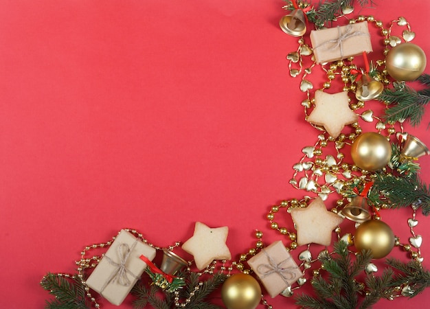 Décor de Noël de branches de sapin et d'épinette, boules jaunes, coffrets cadeaux et biscuits sur rouge