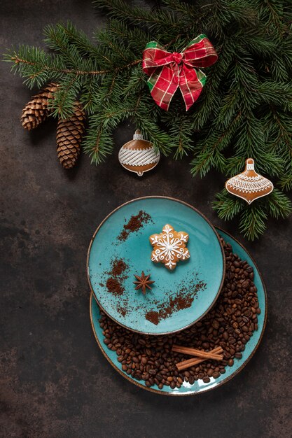 Décor de Noël avec des branches de sapin, poinsettia, pain d'épice et grains de café dans une assiette