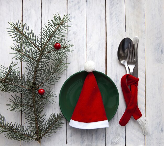 Photo décor de noël avec un chapeau rouge sur fond blanc avec une brindille de sapin